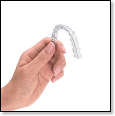example invisalign aligner held up by womans hand - clear braces